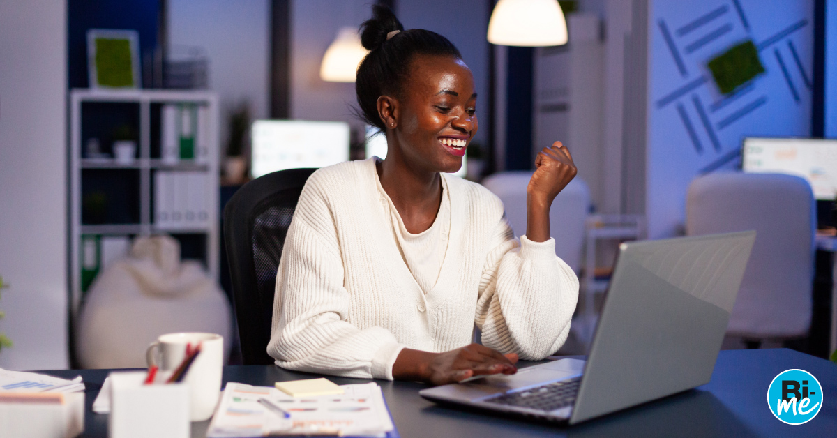 A young lady smiling while working on a laptop