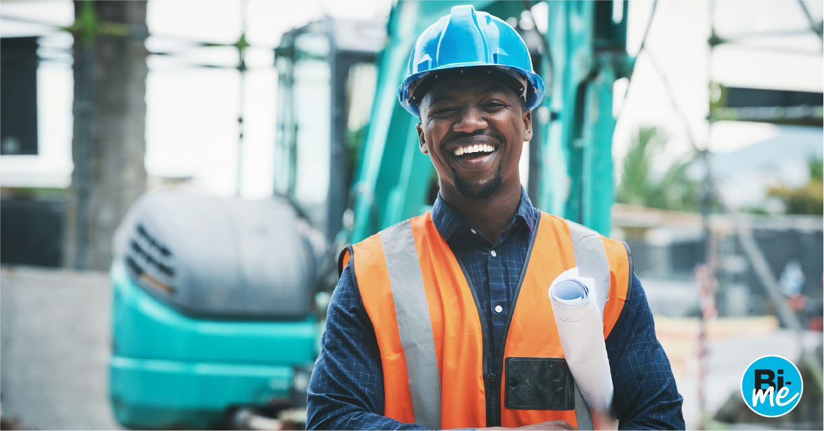 A civil engineer smiling at the camera while in a construction site