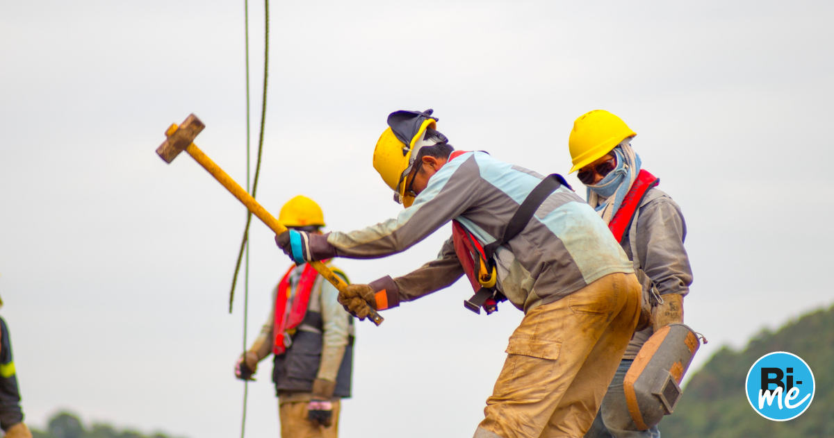 Three construction workers with yellow helmets